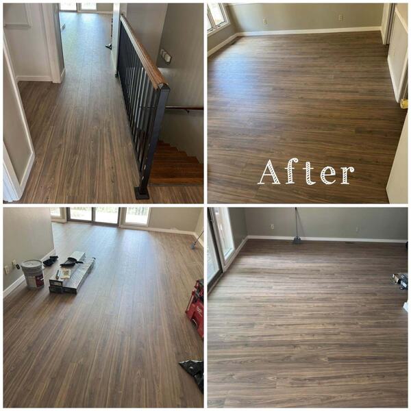 Brown wood look plank flooring in a living room, hallway and on stairs with a black metal railing and wood handrail