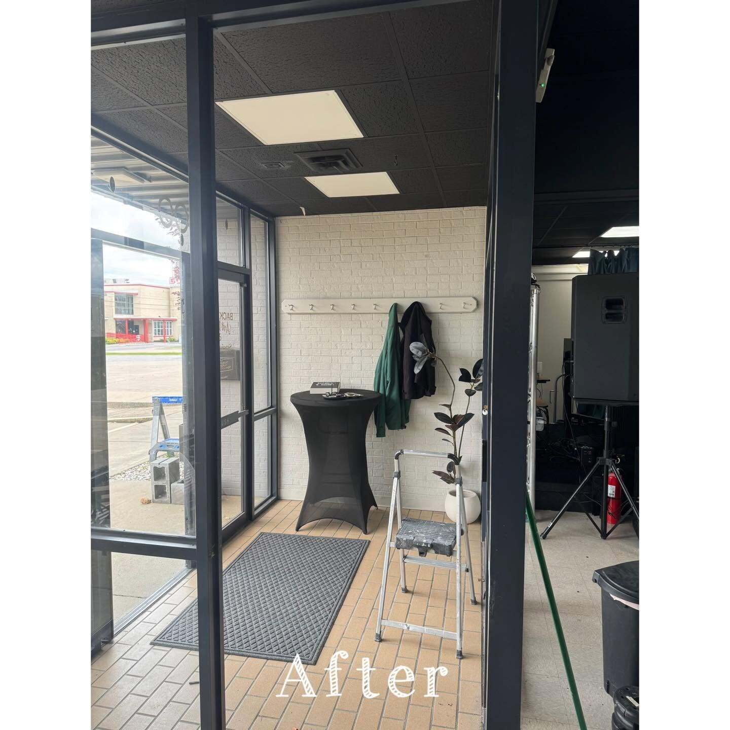 Commercial entryway with painted white brick wall, tile floor, coat hooks, and floor mat