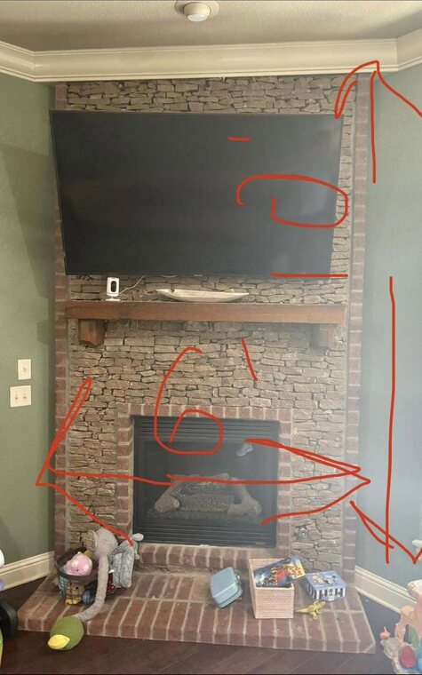 Stacked stone and brick fireplace with mounted flat screen TV and wood mantel marked with red planning lines