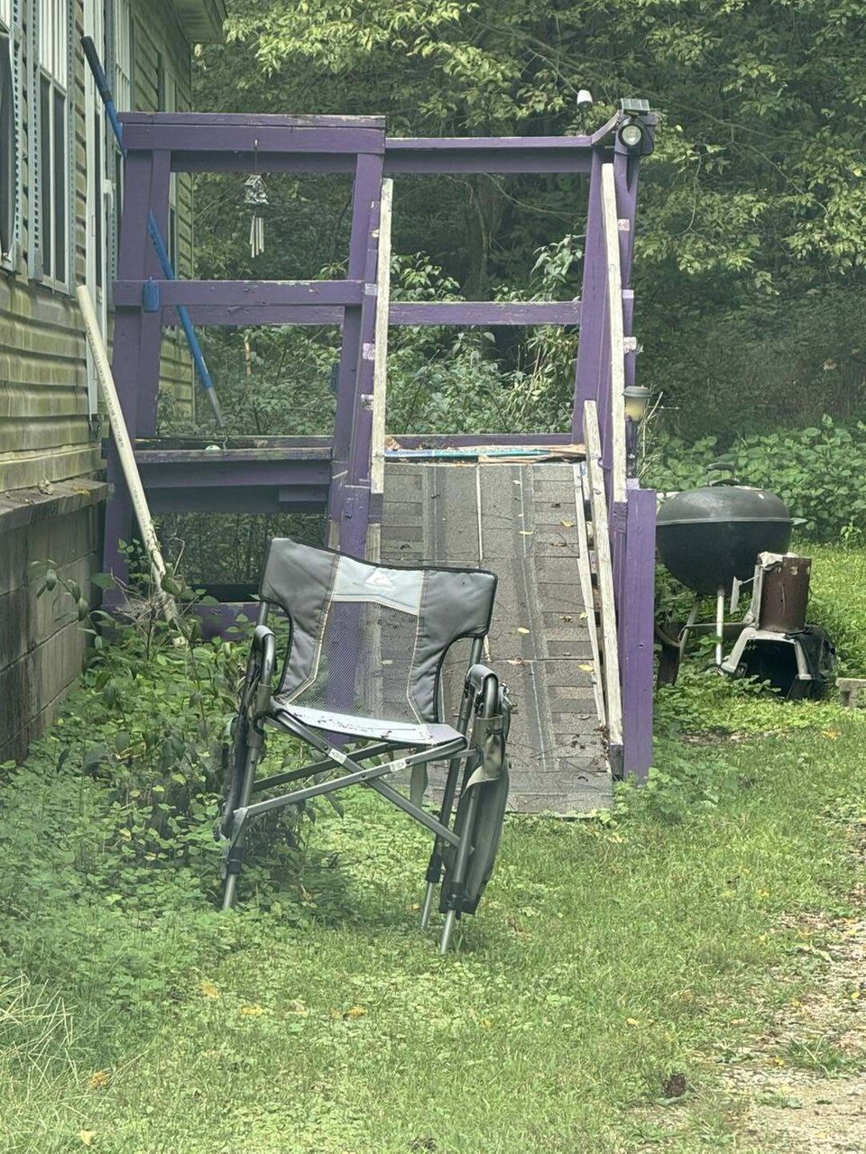 An old purple painted wooden ramp and landing, worn and failing before replacement